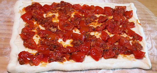 Pizzateig mit Tomaten belegt