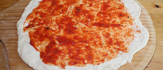 Pizzateig mit Passata bestrichen