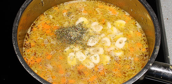 Suppe mit Knoblauch und Majoran kochen