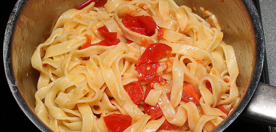 Tagliatelle mit Tomaten und Knoblauch vermischt