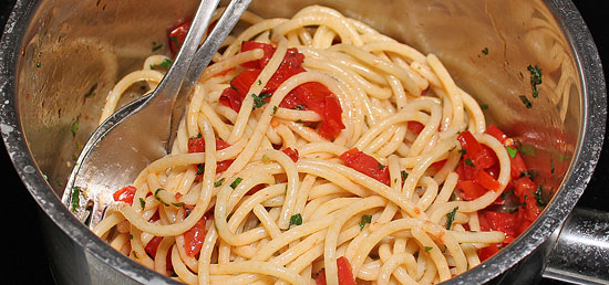 Spaghetti und Tomaten vermischen