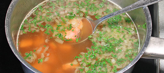 Lachs und Schnittlauch in der Suppe aufwärmen